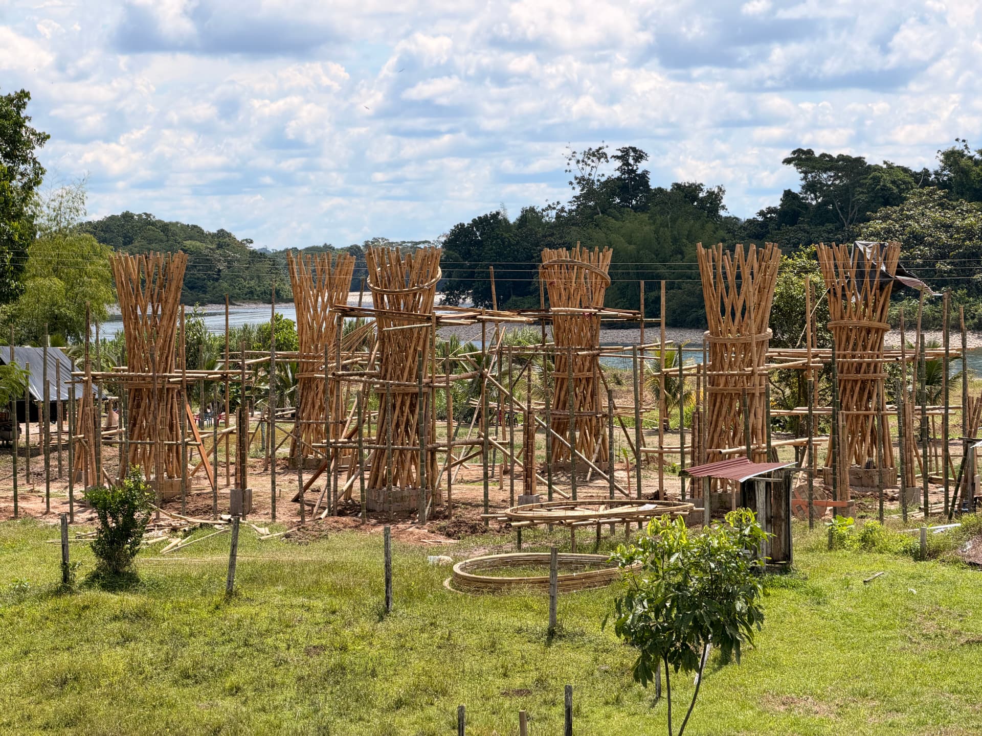 Bamboo pillars rising for the community house at El Diviso, with the Putumayo River behind them