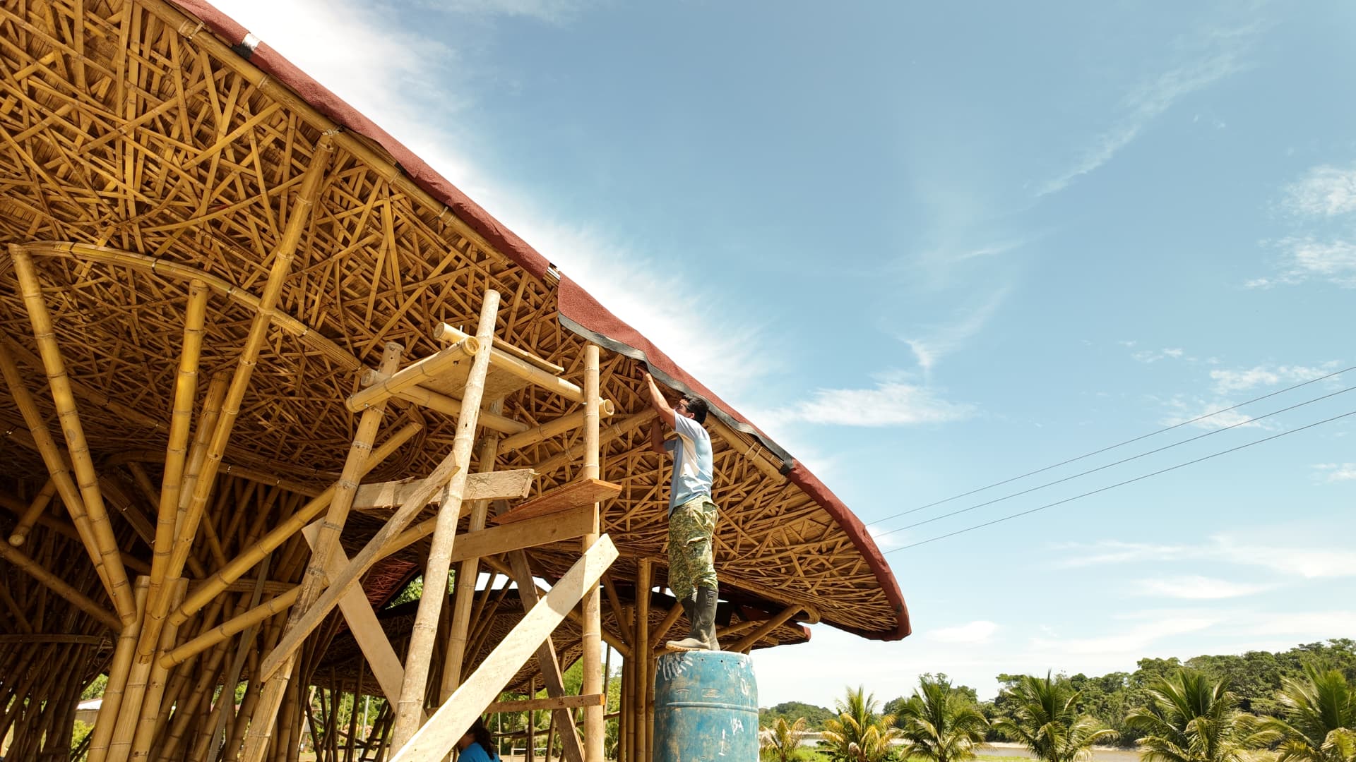 A community member finishing the woven bamboo roof of the cultural center at El Diviso