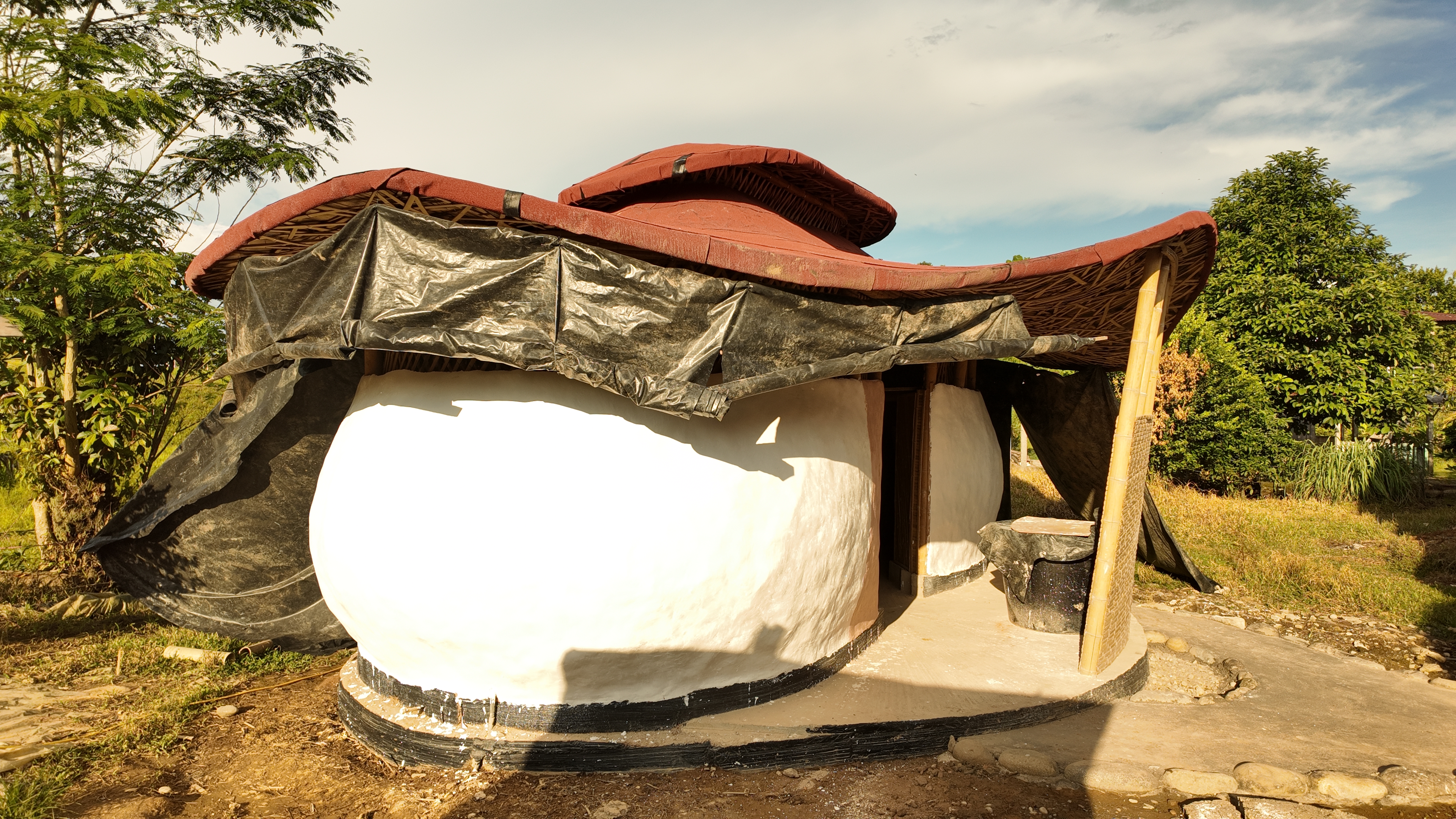 A round earth-block building with its guadua roof at El Diviso