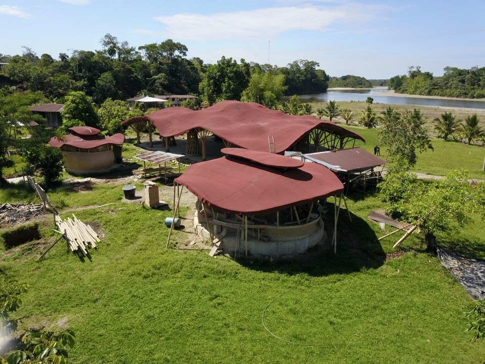 Aerial view of the finished cultural center and community buildings at El Diviso, with the Putumayo River behind