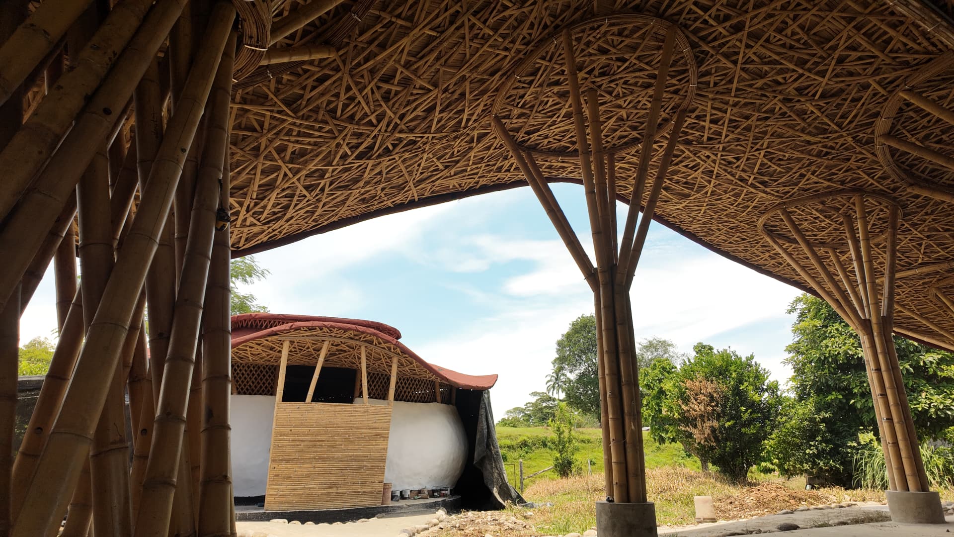 Beneath the woven guadua canopy of the cultural center at El Diviso, with the bamboo dome beyond